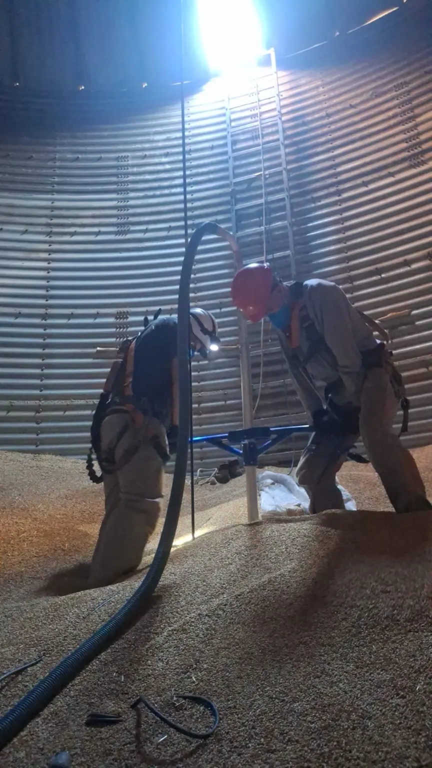 Equipe operando a sonda no interior do silo.